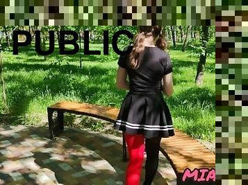 Sexy walks in the park in multi-colored tights in a short skirt with ponytails