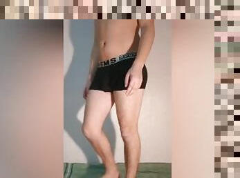 A guy shows what a chastity belt looks like in shorts - a chastity cage in boxer briefs