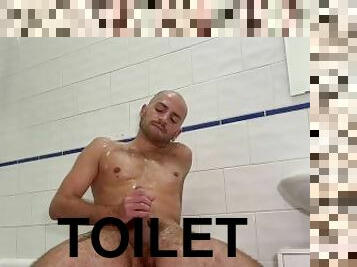Solo bald man wanking and pissing in the toilet
