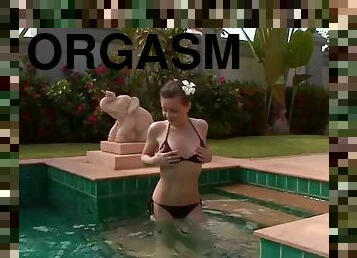 Horny teen fingers her pink pussy inside a pool