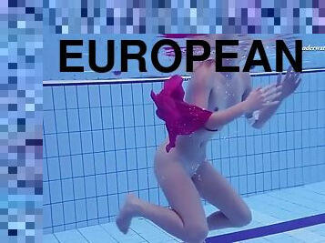 Playful blonde girl swims naked in olympic swimming pool