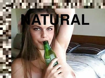 Long-haired babe is sucking that nice bottle