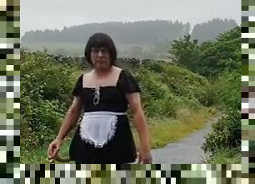 Transvestite maid in a public lane in the rain