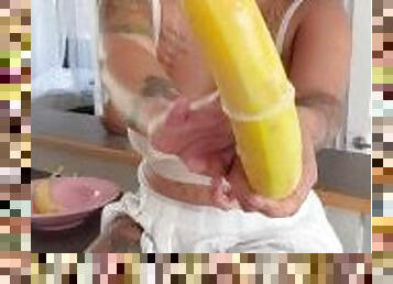 Housewife takes a banana and makes it creamy with a squirt