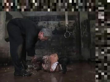 Bondage scene with brunette slut in a water prison