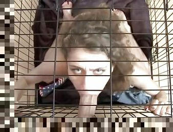 Slut in a cage gives his big dick a BJ
